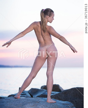 Active naked girl exercising at seaside in evening Active naked girl exercising at seaside in evening 36719013