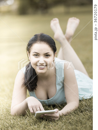 young girl using digital tablet while lying in green spring garden young girl using digital tablet while lying in green spring garden 36720179