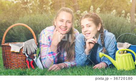 young mother and dauther with gardening tools in outdoors 36720180