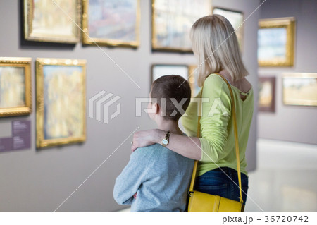 Mother and son regarding paintings in halls of museum Mother and son regarding paintings in halls of museum 36720742