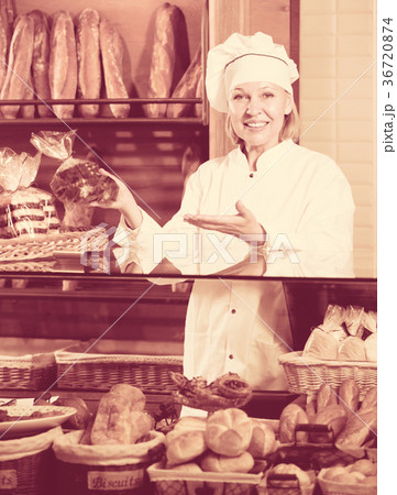 Mature woman selling fresh pastry and baguettes 36720874