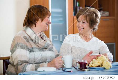 Positive female pensioners drinking coffee and chatting 36720957