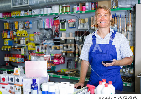 man seller at pay desk in housewares store. 36720996