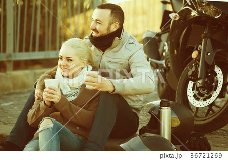 couple posing near motor bike with sandwitches and coffee 36721269