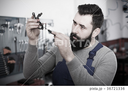 Multi-ethnic guy is observing motorbike part for fixing Multi-ethnic guy is observing motorbike part for fixing 36721336