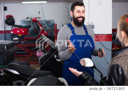 Smiling worker help to woman to repair motorcycle 36721365