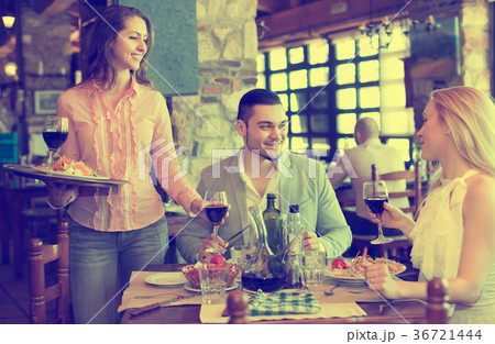 Adults having dinner and waiter Adults having dinner and waiter 36721444