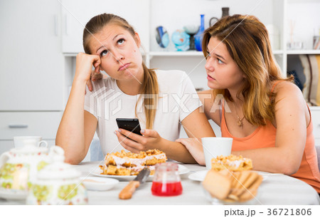 Female talking with young sad friend with mobile 36721806