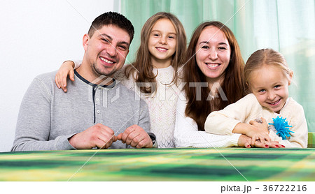 Ordinary happy family of four at table 36722216