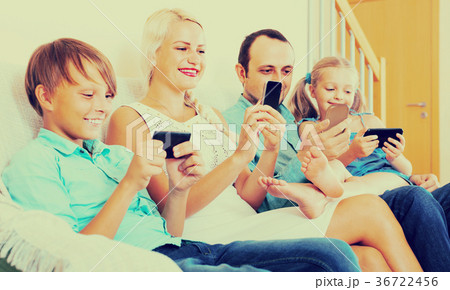 Portrait of family playing with gadgets at home 36722456