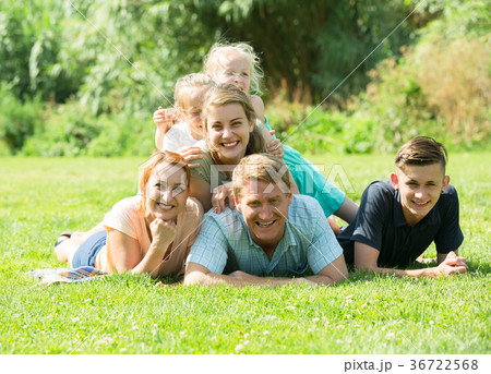 the large family lying on the grass in park. the large family lying on the grass in park. 36722568