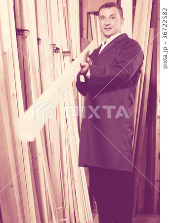 worker holding wooden block in store . worker holding wooden block in store . 36722582
