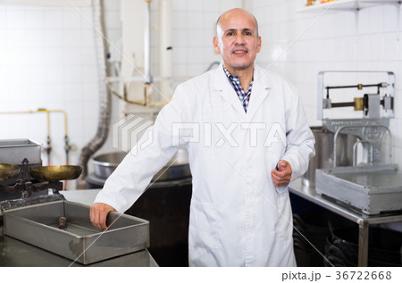 Middle aged worker standing near the table Middle aged worker standing near the table 36722668