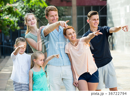 Happy man and woman with kids pointing aside Happy man and woman with kids pointing aside 36722794