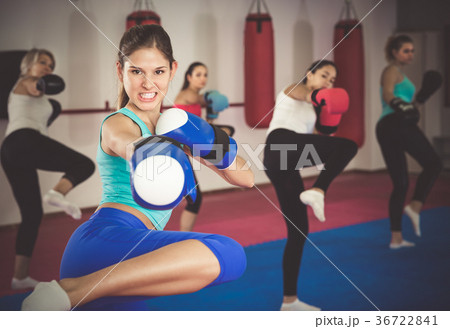Portrait of sporty girl who is boxing with group in gym Portrait of sporty girl who is boxing with group in gym 36722841