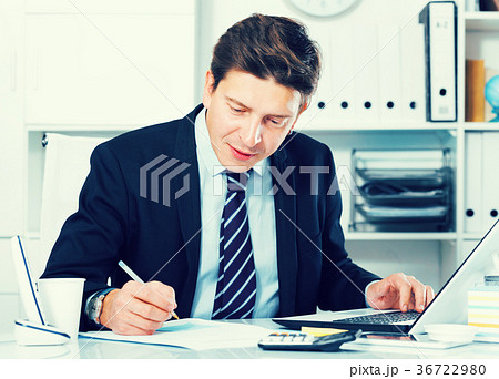 Businessman in office clothes filling up documents 36722980