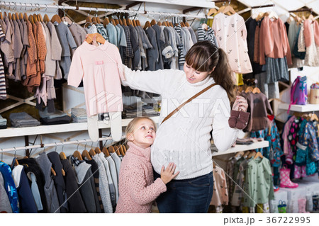 Woman and child searching clothes for newborn 36722995