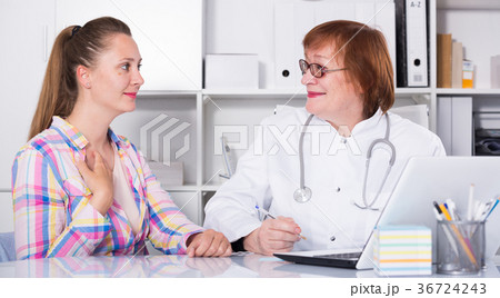 Portrait of mature medical worker talking with patient 36724243