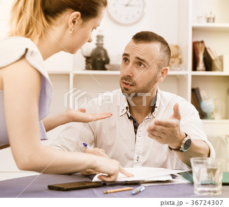 Husband is studying documents on divorce at the table 36724307