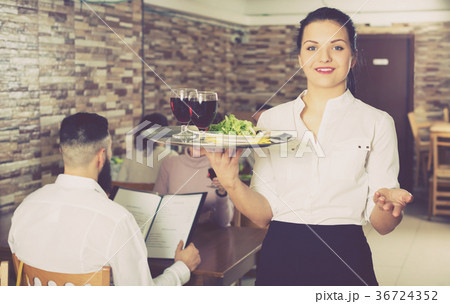 Professional waitress greeting customers at table 36724352