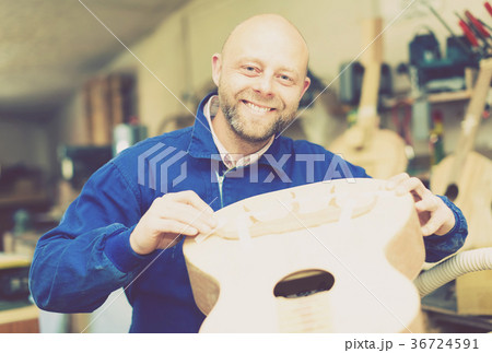 Successful guitar maker in workshop 36724591
