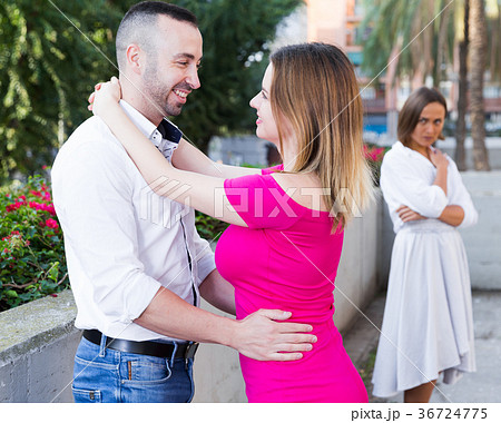 Cheerful couple are talking and woman is envying them Cheerful couple are talking and woman is envying them 36724775