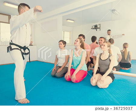 Young instructor is showing new martial moves to adults 36725037