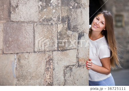 Girl peeking out from behind wall, copyspace 36725111