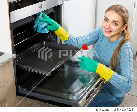 Young maid doing oven clean-up. 36725413