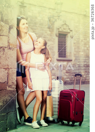 Portrait of mother and daughter travelling together resting near old building Portrait of mother and daughter travelling together resting near old building 36726368