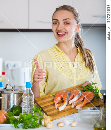 Girl in yellow blouse with fresh salmon fillet 36726658