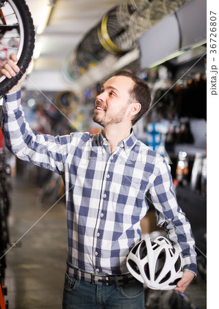 Male 28-34 years old is choosing in sports store convenient bike Male 28-34 years old is choosing in sports store convenient bike 36726807