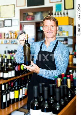 Male seller with wine bottle in hands Male seller with wine bottle in hands 36727258