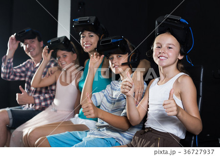 Smiling aughter watching the video with family 36727937