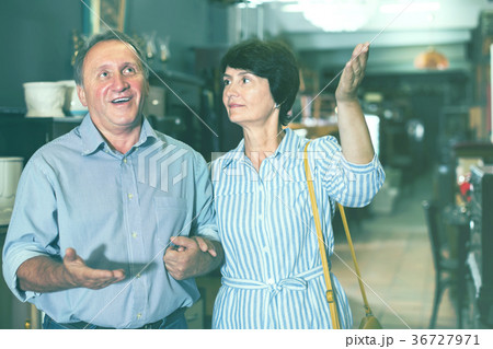 cheerful adult woman with her husband are buying furniture in antique store cheerful adult woman with her husband are buying furniture in antique store 36727971