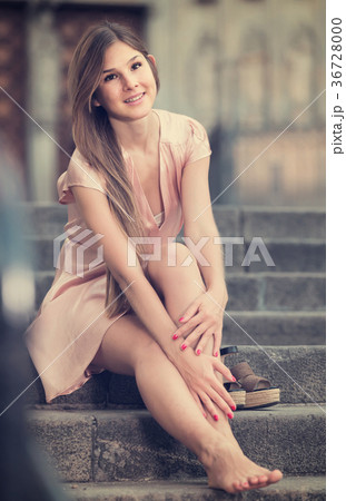 young female in rose dress sitting in city young female in rose dress sitting in city 36728000