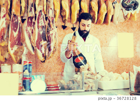 Smiling male seller showing jamon 36728128
