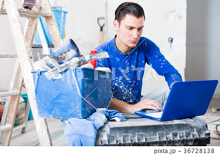Male contractor with laptop in repairable apartment Male contractor with laptop in repairable apartment 36728138