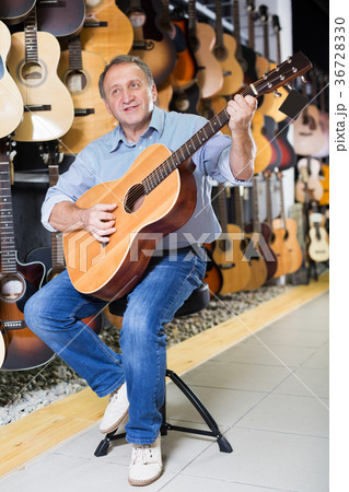 Man is playing on acoustic guitar 36728330