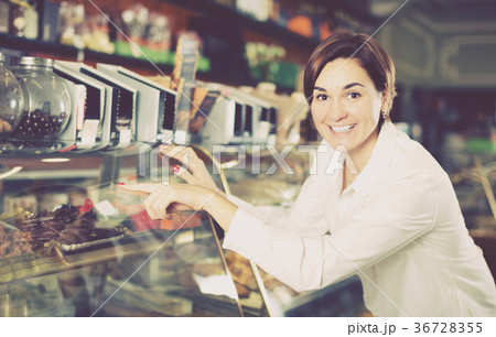 Girl deciding on best dessert in confectionery Girl deciding on best dessert in confectionery 36728355
