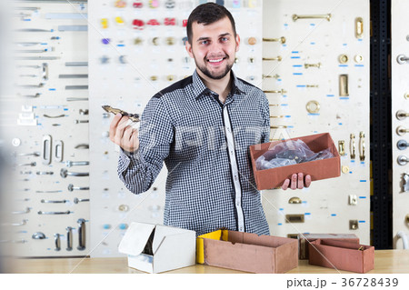 Laughing seller checking boxes with door handles 36728439