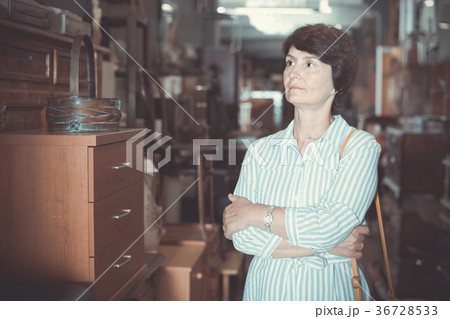 Mature woman is shopping the old furniture Mature woman is shopping the old furniture 36728533