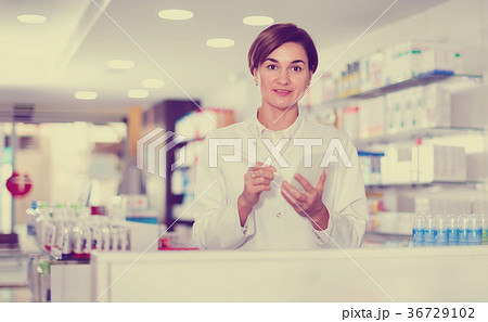 Female pharmacist noting assortment of drugs Female pharmacist noting assortment of drugs 36729102