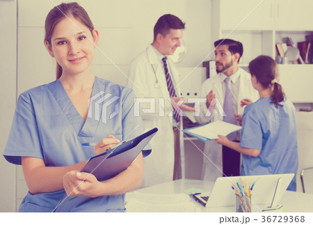 Female doctor writing notes on clipboard 36729368