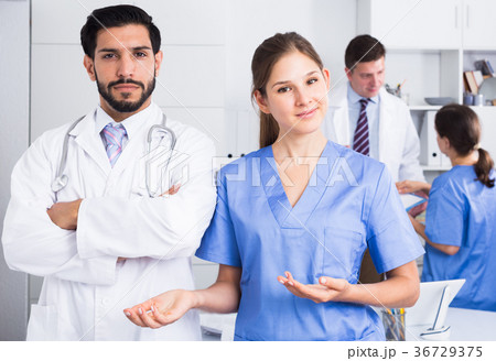 Female doctor with male colleague inviting in clinic Female doctor with male colleague inviting in clinic 36729375