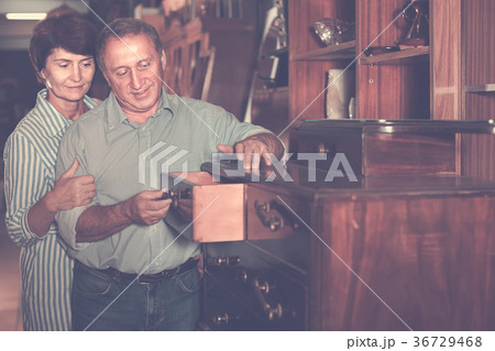 adult woman with her husband are buying antique curbstone in store 36729468
