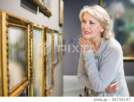 Female visitor looking at artwork painting in the museum indoors 36730147