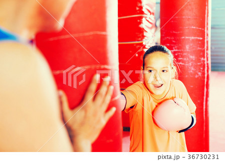 Girl with boxing gloves posing in defended stance 36730231