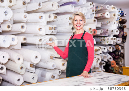 Female seller is demonstrating fabrics Female seller is demonstrating fabrics 36730348