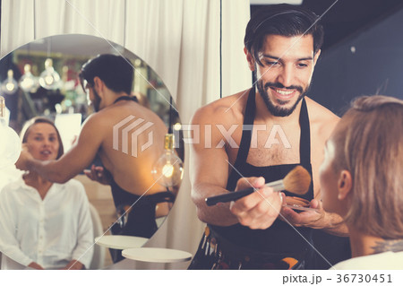 Cheerful male makeup artist applying cosmetics 36730451